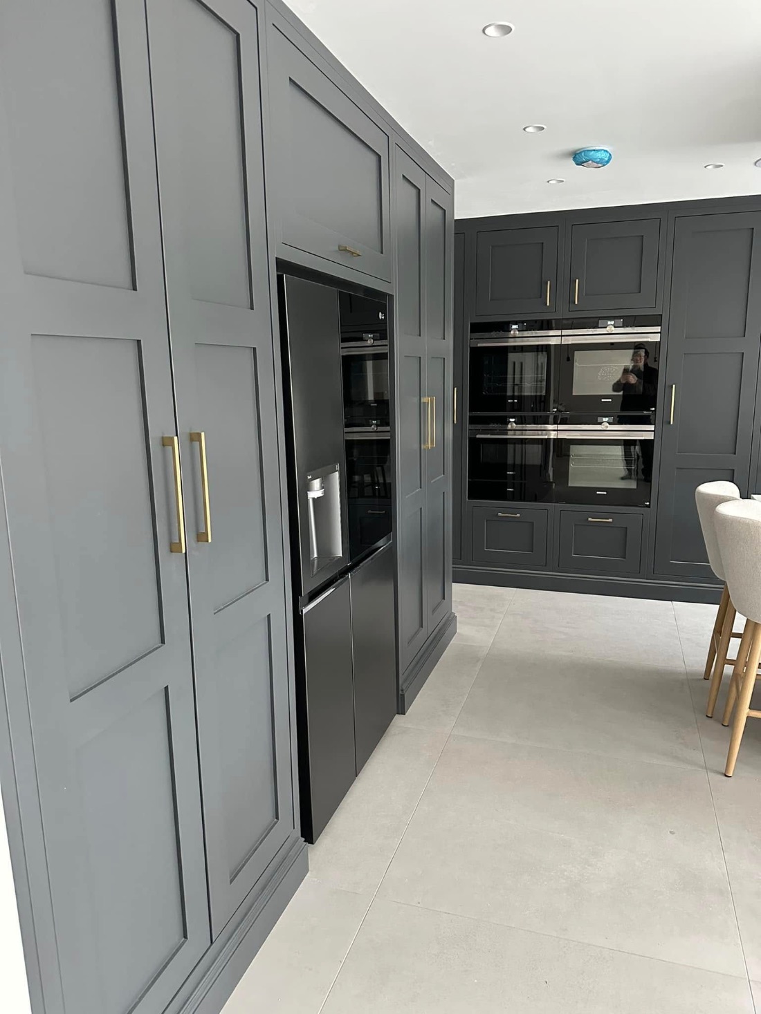 Tall grey shaker kitchen units with brass handles